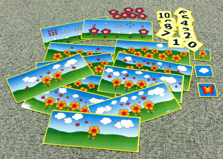 Игра «Учимся считать», от 2,5-3 до 7 лет Россия В комплекте 12 больших карточек и 24 маленьких. Цель игры: обучение навыкам счёта, подготовка к арифметике.
Первая игра. На каждой из 10 больших карточек изображено различное количество бабочек, цветочков и облаков. Взрослый берёт маленькую карточку с изображением бабочек, либо цветочков, либо облаков. Кладёт эту маленькую карточку с левой стороны от большой панели и объясняет ребёнку, что нужно сосчитать на большой панели. Над большой карточкой, вверху выкладываются все маленькие карточки с цифрами от 0 до 10. Ребёнок осуществляет пересчёт указанного на маленькой карточке изображения, выбирает итоговую цифру и кладёт её справа от панели.
Вторая игра. Взрослый берёт одну из двух больших панелей с изображением 5 стебельков и бабочек над ними. Ребёнок считает количество бабочек и находит цветочек с цифрой, соответствующей для данного количества бабочек, и прикладывает его к этому стебельку. Далее подсчёт бабочек над стебельками продолжается.
Начинать надо с самого простого и при необходимости помогать ребёнку в освоении навыка счёта. Карточки также могут использоваться для выяснения овладения ребёнком навыков счёта. Все карточки в тонком ламинате.